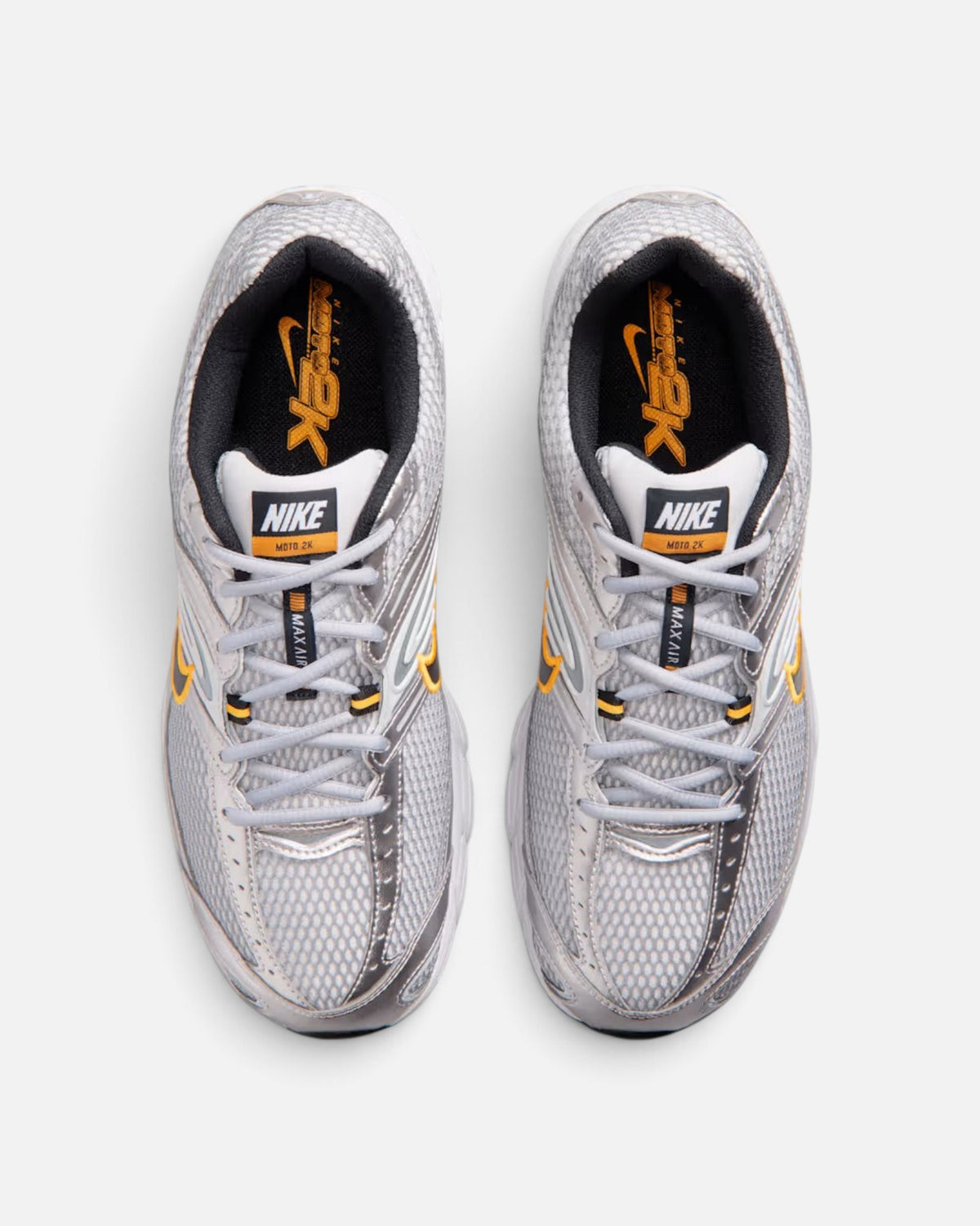 CRIUW Nike Air Max Moto 2K sneakers in wolf grey with metallic silver accents and orange detailing, top-down view.