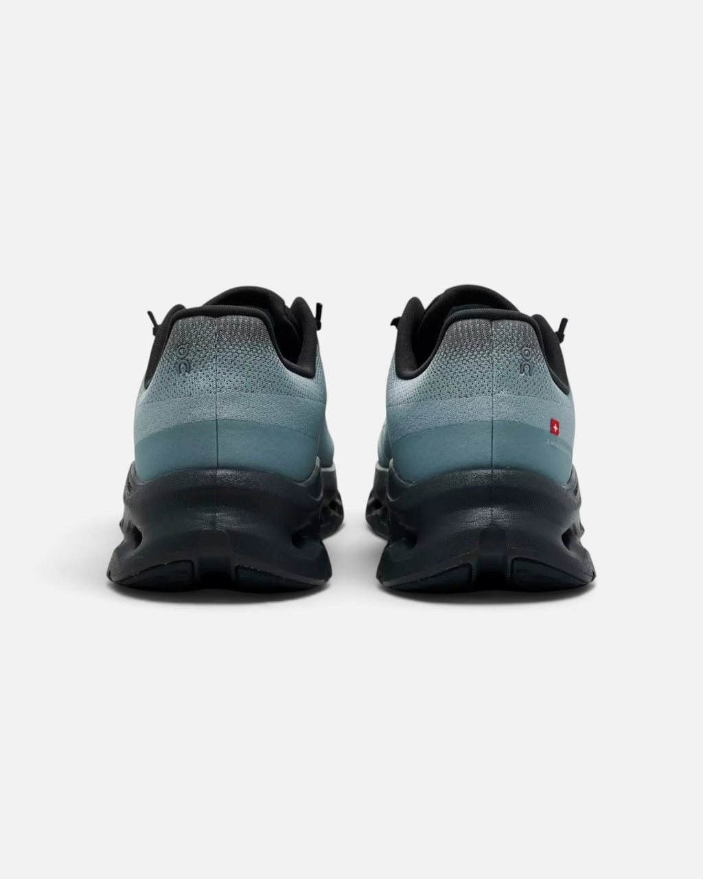 CRIUW ON Cloudtilt sneakers in wash eclipse blue and black, showing the rear view of the cushioned performance soles.